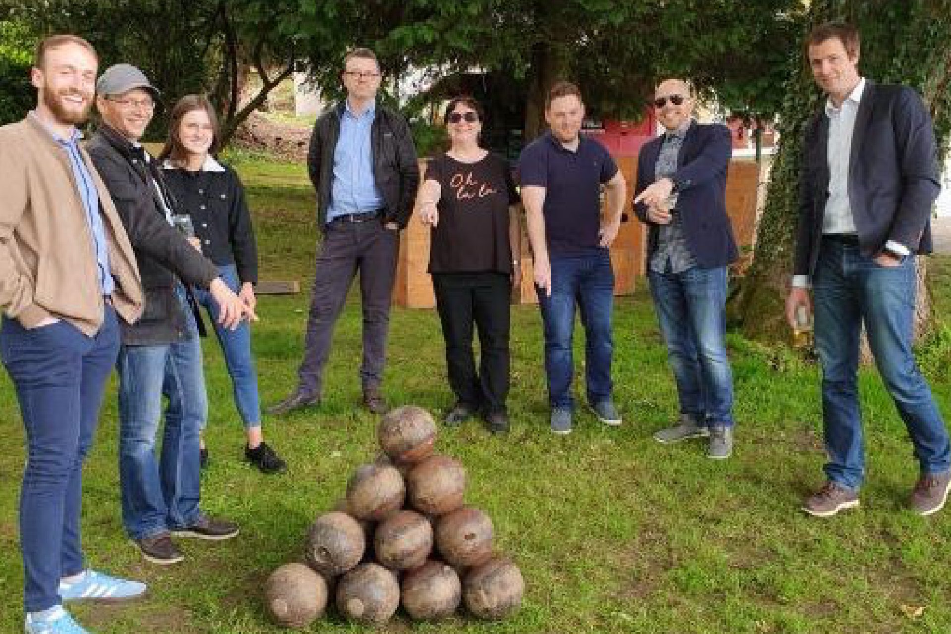 Corporate-06 Group standing around stacked cannonballs outdoors